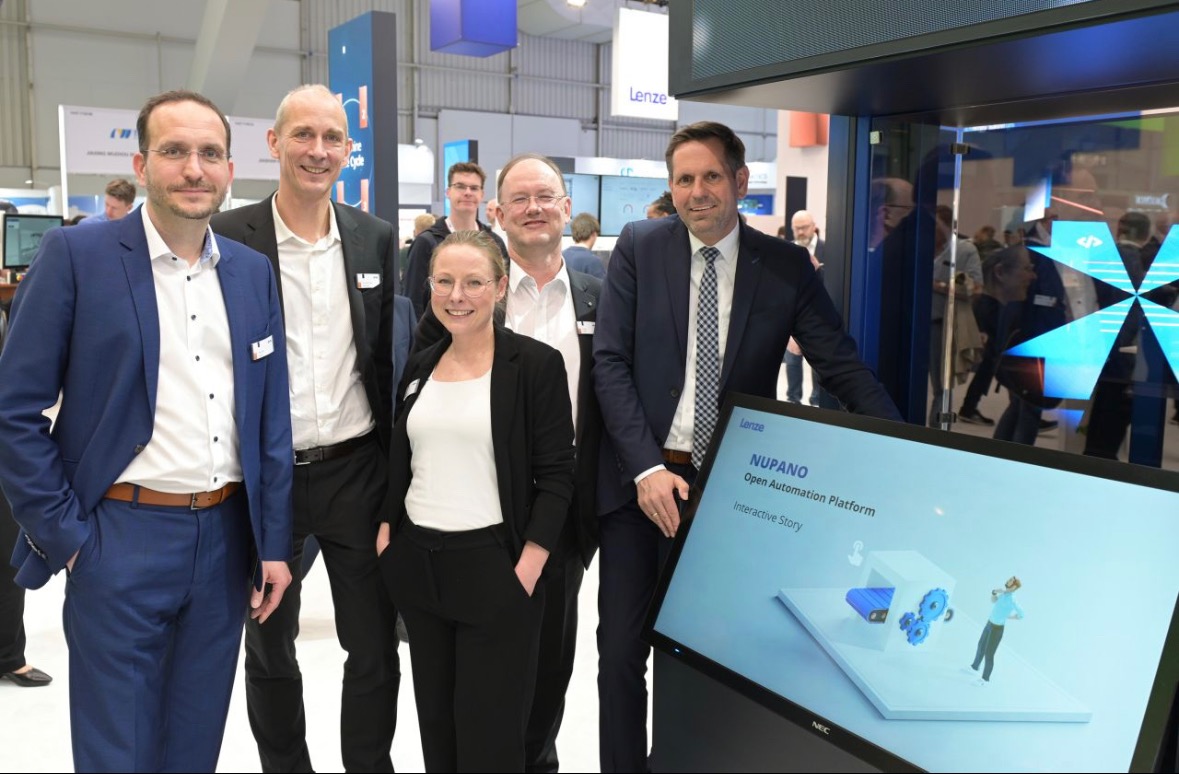 Eine Gruppe von Lenze SE Mitarbeitern steht vor einem großen Bildschirm, auf dem eine interaktive Anwendung von creanovo läuft.